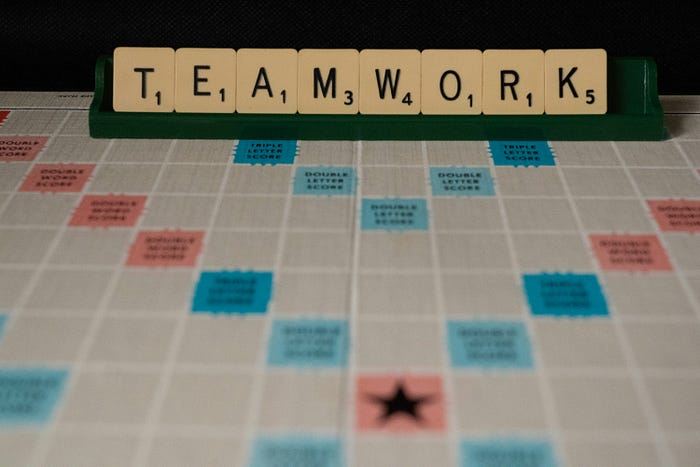 Scrabble board with ‘TEAMWORK’ spelled out – collaboration and success concept in a game setting.