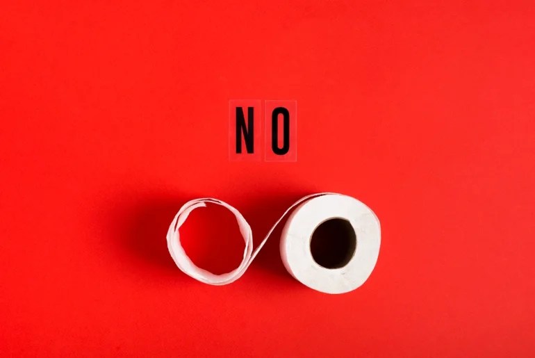 Creative typography concept using toilet paper to spell ‘NO’ on a bold red background – minimalist and symbolic message.