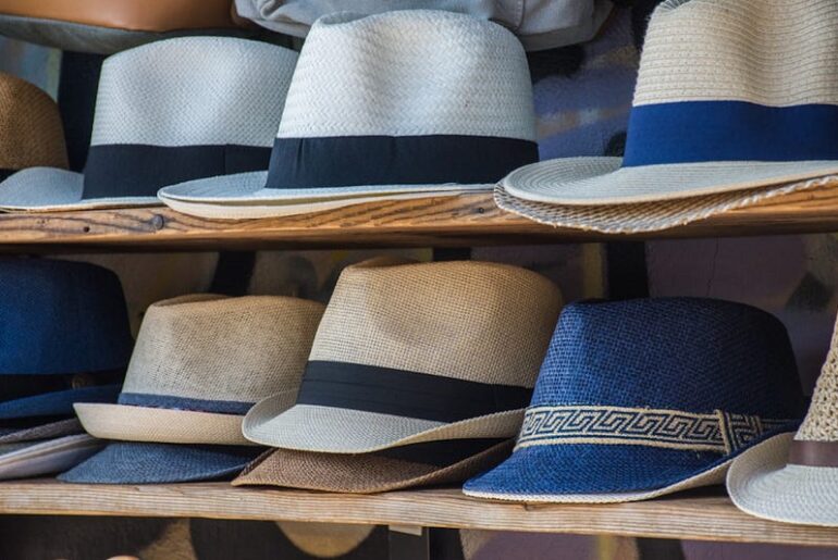 Panama hats for sale on wooden shelves – stylish woven straw hats with black, blue, and patterned bands, perfect for summer fashion and sun protection.